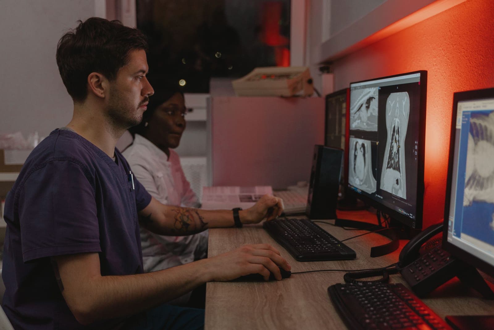 Profissionais de saúde analisando imagens de tomografia em monitores