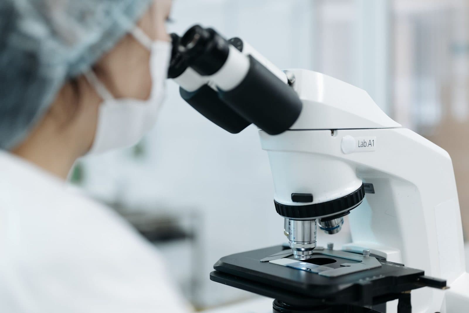 Profissional de laboratório examinando lâmina de tecido ao microscópio